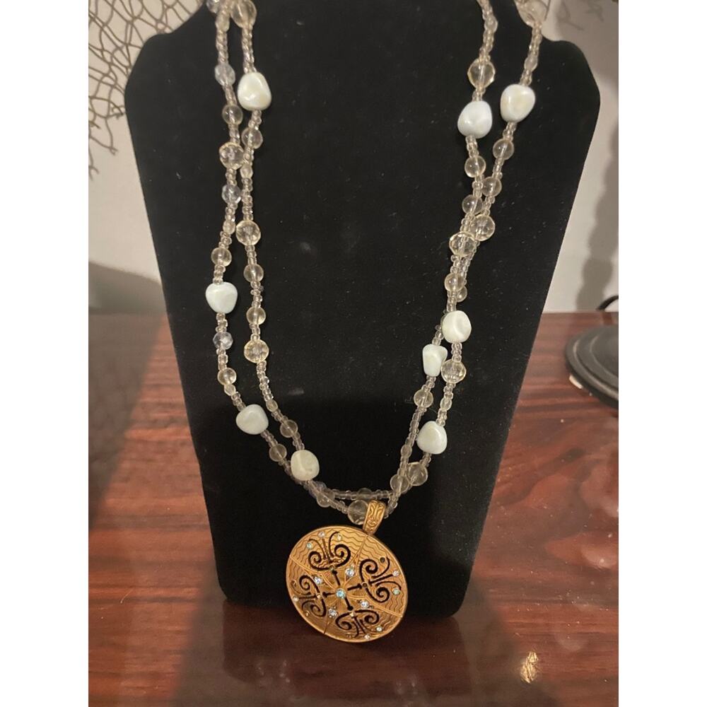 Gold medallion statement necklace. The chain is silver with white stones